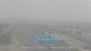 hard to see image of highway with traffic in dust storm with Alaskan Air Conditioning and Heating logo and contact phone numbers in bottom section